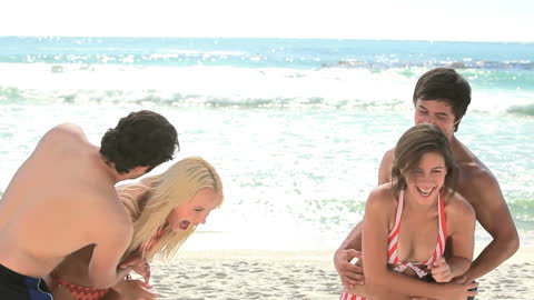 Happy Couples Enjoying Fun Day at Beach