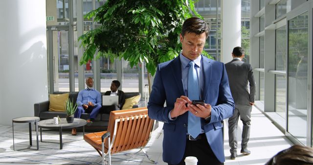 Businessman Texting on Smartphone in Modern Office Lobby - Download Free Stock Images Pikwizard.com