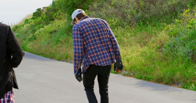 Young Man Adjusting Skateboard on Scenic Outdoor Path - Download Free Stock Images Pikwizard.com