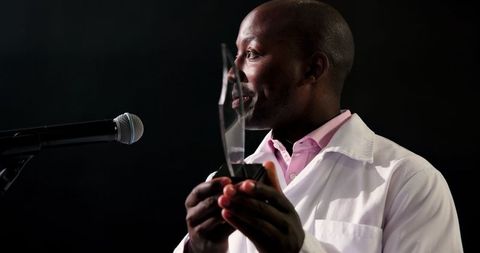 Doctor holding award on stage at recognition ceremony