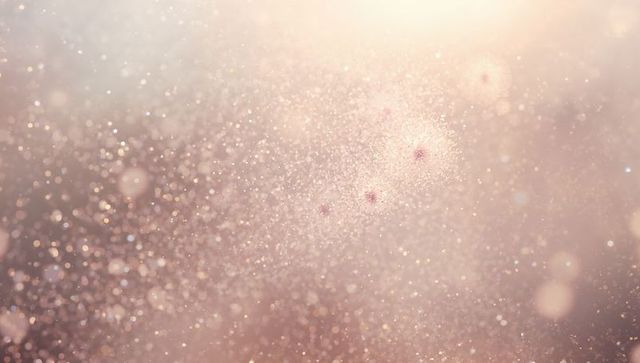Rose gold glitter bokeh with soft sparkle, ethereal dust motes and warm glow