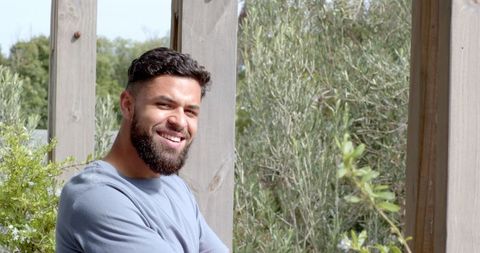 Smiling Man Enjoying Relaxed Moment on Sunny Outdoor Patio