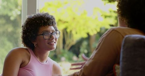 Smiling Woman Chatting by Window in Bright Room