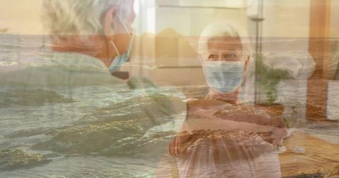 Reaching senior couple wearing masks in assisted living with ocean waves double exposure