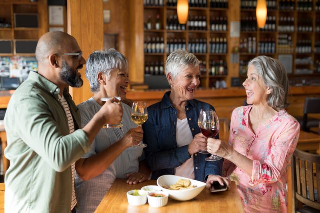 Group of senior friends enjoying drinks and conversation in a cozy bar. Perfect for illustrating social gatherings, friendship, leisure activities, and senior lifestyle. Ideal for use in advertisements, social media posts, and articles about socializing, retirement, and enjoying life.