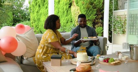 Couple Celebrating Birthday with Cake and Champagne on Patio