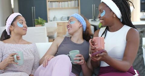 African american friends enjoying home spa morning with eye patches and cozy coffee