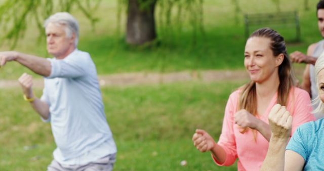 Group engaged in a fitness activity outdoors in a park, with diverse participants including senior individuals and young women. Ideal for promoting active and healthy lifestyle campaigns, recreational programs, or senior community activities. Perfect for use in wellness adverts or healthy living articles.