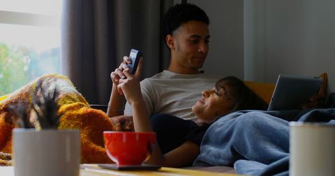 Couple relaxing with digital devices at home
