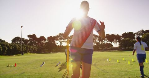 Young Athletes Training on Sunlit Soccer Field