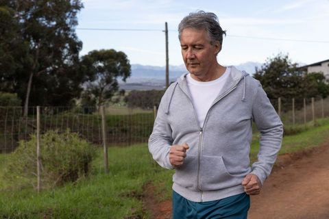 Mature Man Jogging Peacefully on Rural Pathway Outdoors