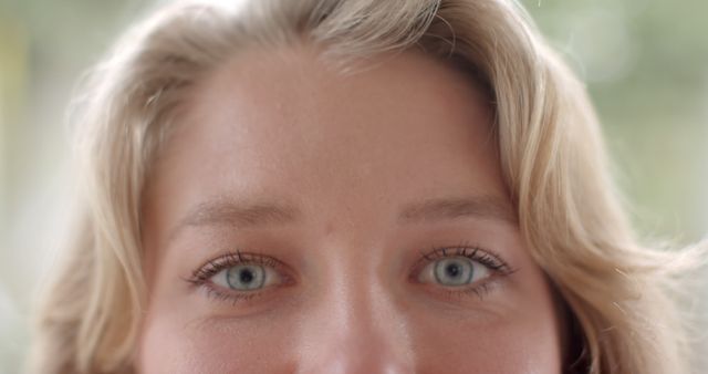 Portrait close up of blonde caucasian woman opening blue eyes and smiling. Domestic life and lifestyle, unaltered.