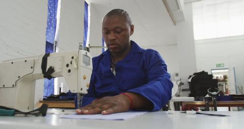 Worker sewing in wheelchair factory workshop