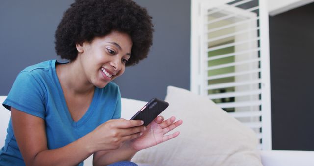 Happy African American Woman Texting on Smartphone in Modern Living Room - Download Free Stock Images Pikwizard.com