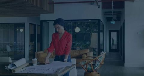 Designer Reviewing Blueprints in Modern Office Studio