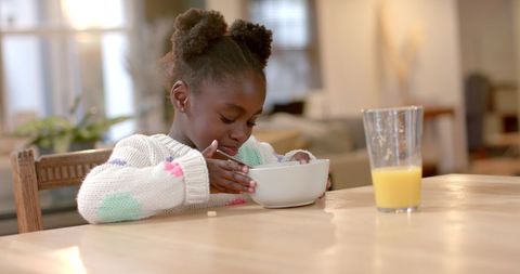 Young Girl Enjoying Breakfast Cereal in Cozy Kitchen - Download Free Stock Images Pikwizard.com