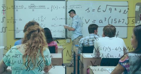 Math professor teaching college students in classroom