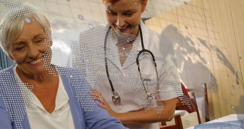 Nurse Consulting With Elderly Woman at Clinic Table Reviewing Chart and Providing Compassionate Care