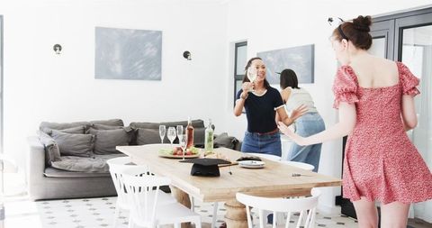 Happy Friends Celebrating Graduation with Toast in Sunlit Dining Room