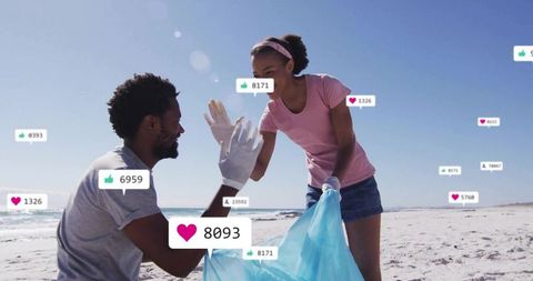 High-fiving volunteers cleaning beach with social engagement