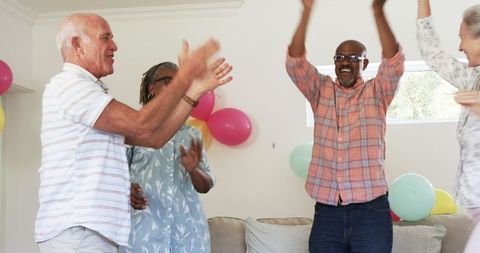 Senior Friends Dancing Joyfully at Home During Celebration