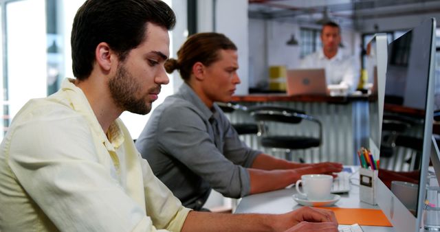 Focused Young Professionals Working at Modern Office Desk - Download Free Stock Photos Pikwizard.com