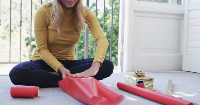 Woman Wrapping Gifts at Home on Floor Near Open Door - Download Free Stock Images Pikwizard.com
