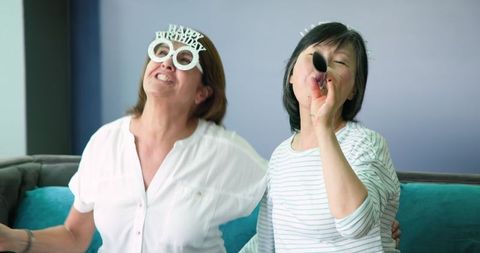 Joyful senior friends celebrating birthday at home