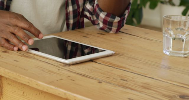 Person using tablet at wooden table in cafe, close-up - Download Free Stock Images Pikwizard.com