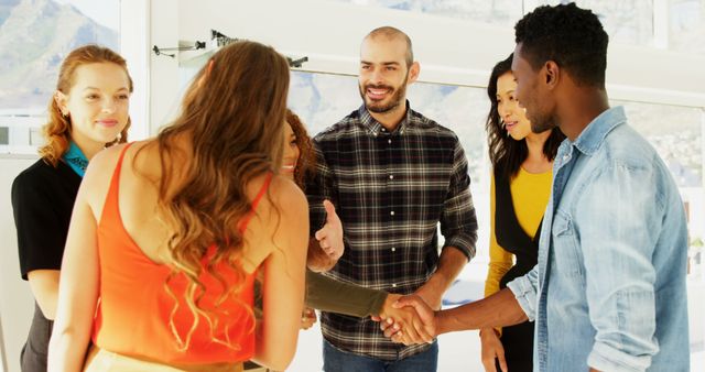 Diverse young adults are engaged in a friendly handshake, with copy space - Download Free Stock Photos Pikwizard.com