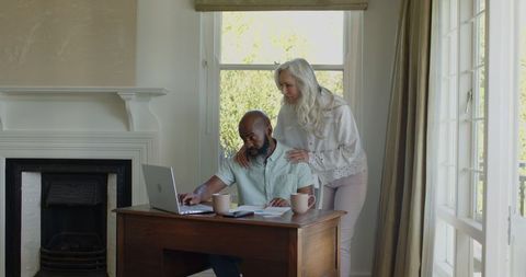 Elderly Couple Using Laptop for Planning at Home