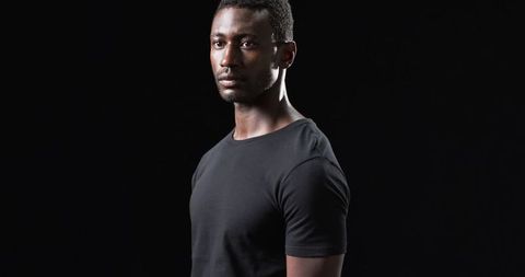 Athletic Man in Black Shirt Against Dark Background
