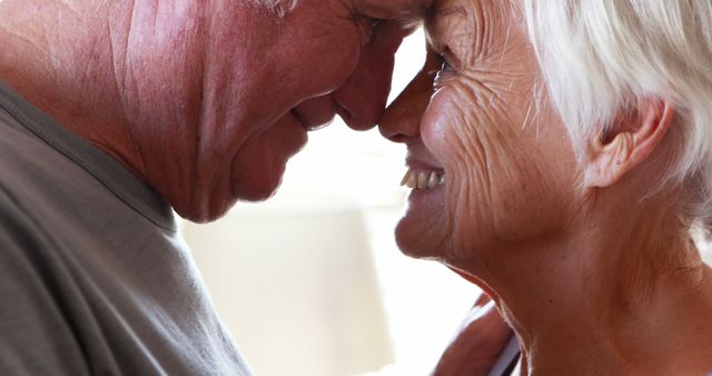 Happy senior couple romancing in bedroom at home