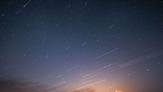 Star Trails Illuminate Night Sky with Meteors and Clouds