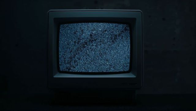 Vintage CRT Monitor with Blue Static in Dark Room
