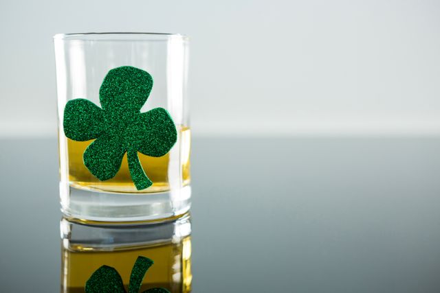 St Patricks Day glass of beer with shamrock on white background
