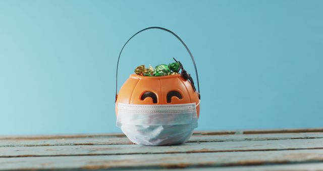 Halloween Pumpkin Bucket with Candy Wearing Protective Mask - Download Free Stock Images Pikwizard.com