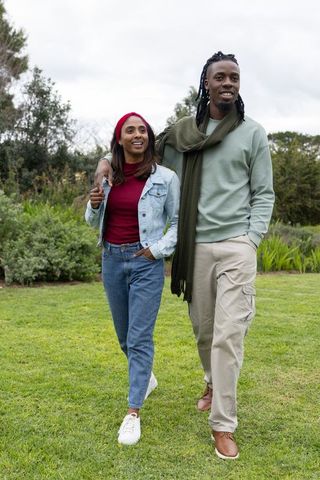 African american man and indian woman walking in park during casual outdoor stroll