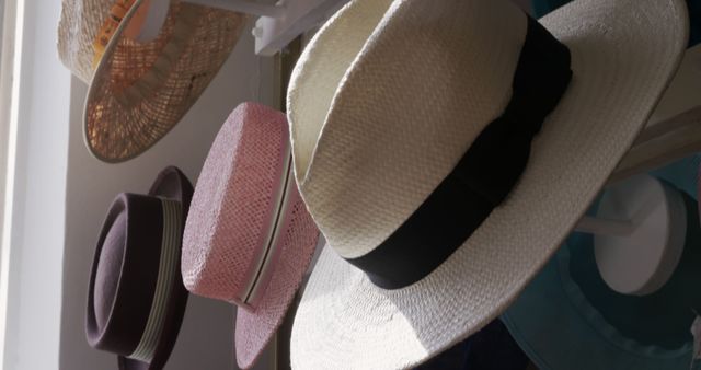 Collection of diverse hats including straw, wide-brimmed, and summer hats hanging proudly on display. This image is ideal for use in fashion-related projects, blogs about summer accessories, or as a visual element for online stores selling headwear.