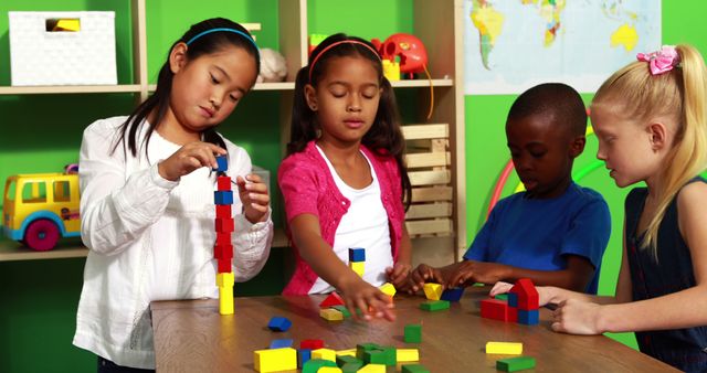 Cute classmates playing with building blocks in playschool