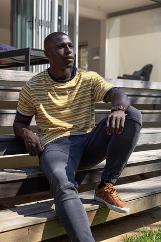 Man Relaxing on Modern Outdoor Steps in Striped Shirt