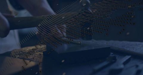 Artisan hammering and shaping metal with chisel on bench block, binary data overlay