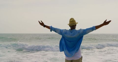 Man Embracing Ocean Breeze on Serene Beach - Download Free Stock Images Pikwizard.com