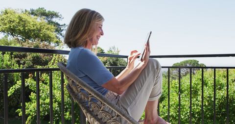 Senior Woman Using Tablet Outdoors for Video Call
