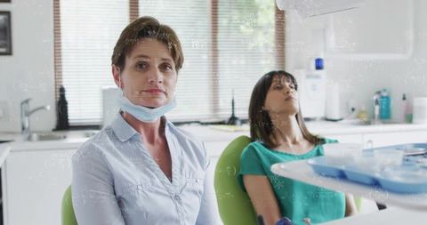 Female dentist wearing mask examining patient in modern dental clinic