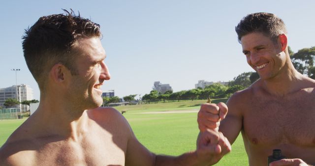 Three shirtless diverse fit men smiling and fist bumping after exercising outdoors - Download Free Stock Photos Pikwizard.com