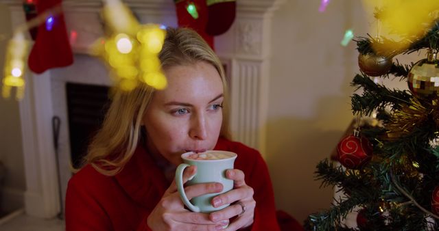 Woman Enjoying Hot Cocoa by Christmas Tree - Download Free Stock Images Pikwizard.com