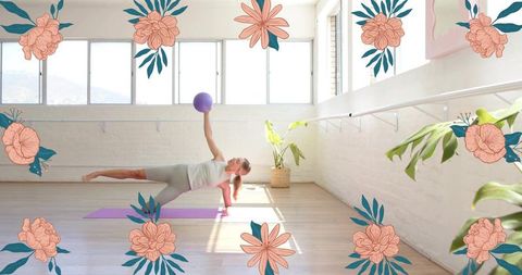 Sunlit studio woman balancing in side plank holding purple fitness ball on yoga mat core