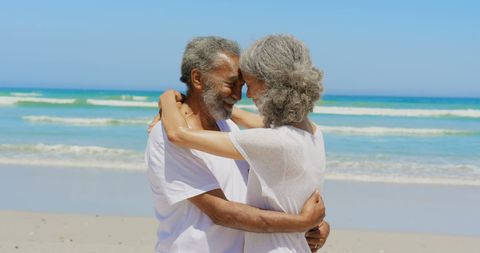 Senior Couple Embracing at Beach with Joyful Expressions