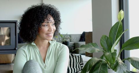 Thoughtful Woman Relaxing Near Window in Modern Living Room